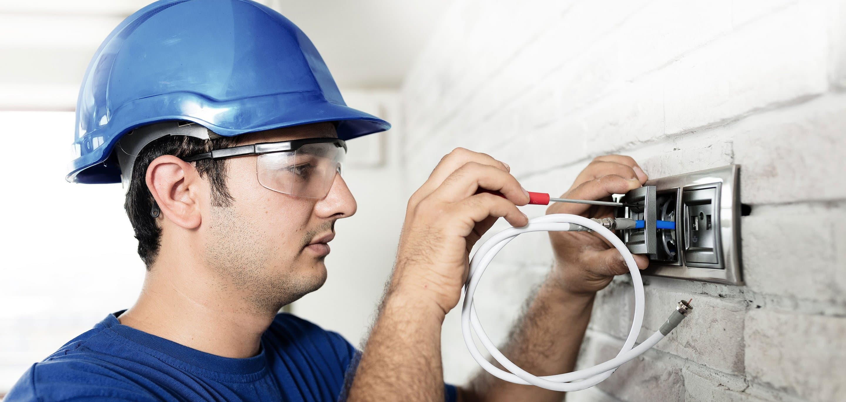 Techniker setzt Anschlussdose. Symbolbild für Leistungen und Technik von NetCologne.