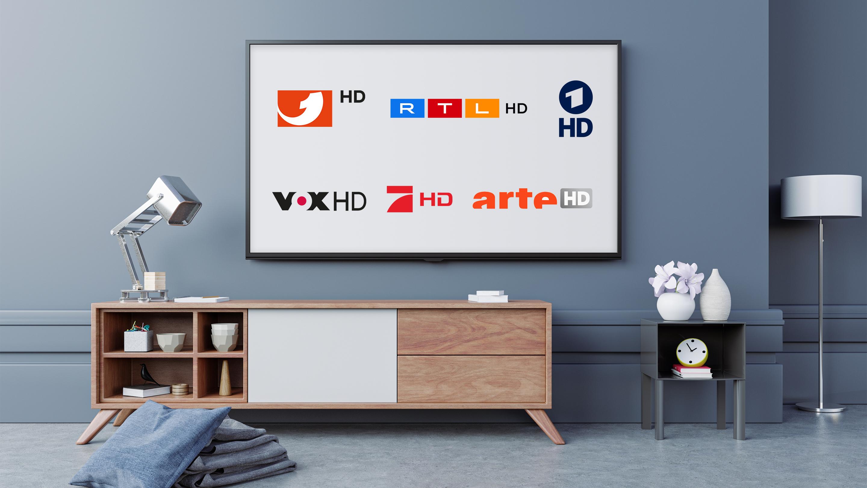 Fernseher an der Wand hängend auf dem Logos verschiedener Fernsehsender zu sehen sind