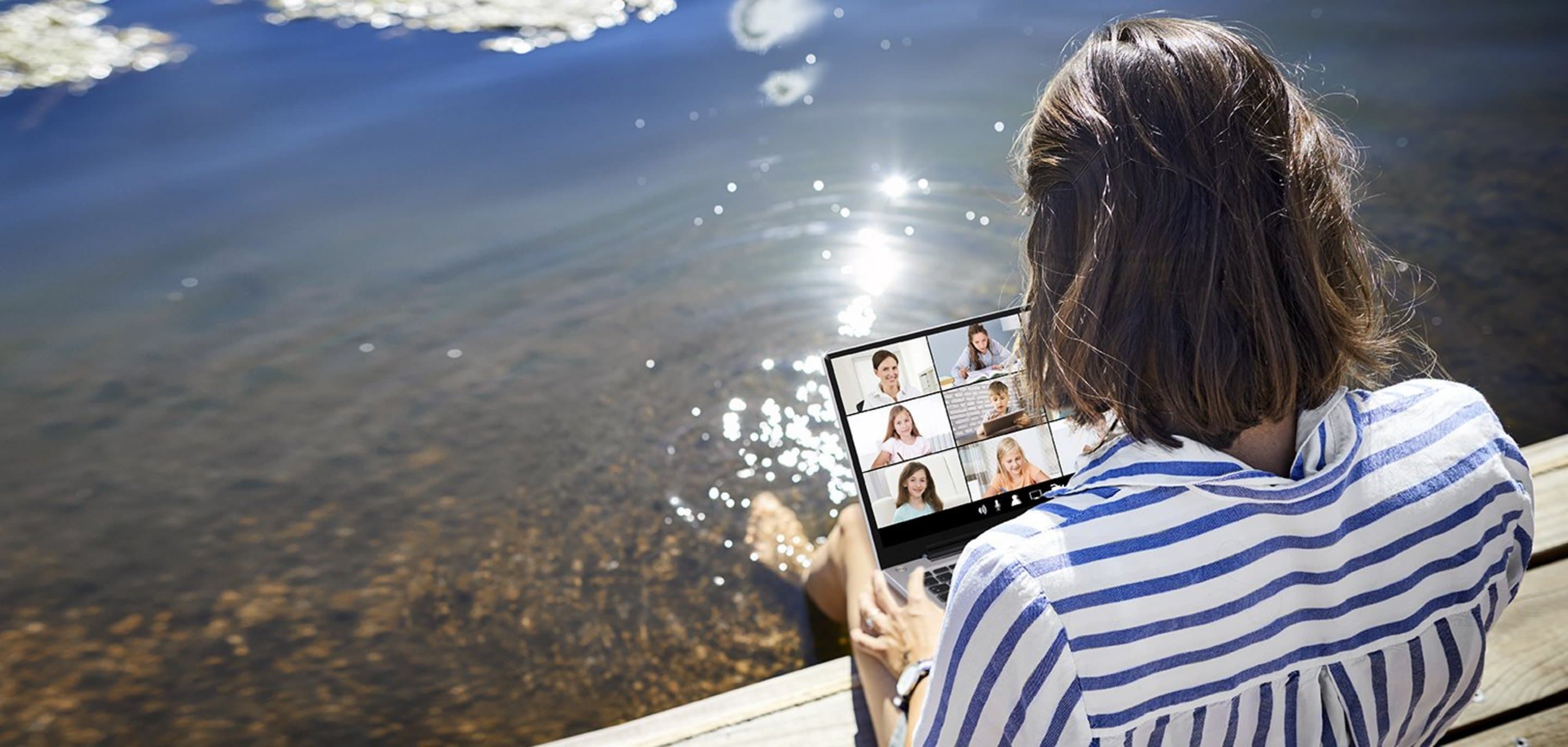 NetConnect WLAN für unterwegs Frau schaut auf ihr Tablett und sitzt am Ufer