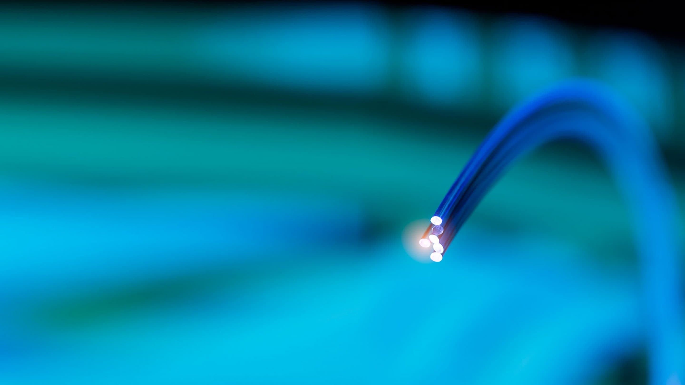 Ausbau_FTTH Grünblauer Hintergrund mit Glasfaserkabeln